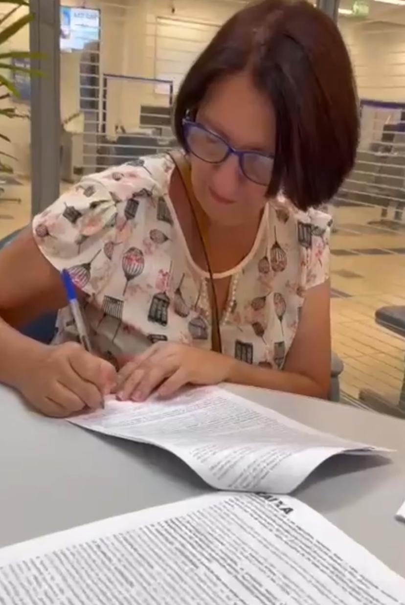 Cliente assinando a documentação do financiamento na agência